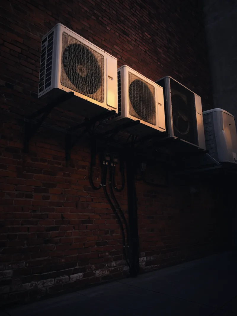Four heat pumps on one brick wall