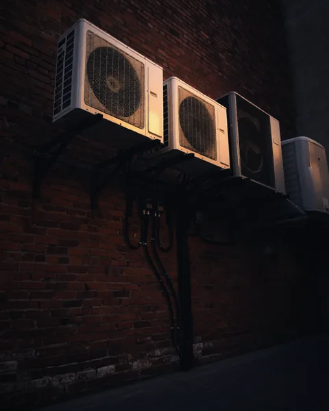 Four heat pumps on one brick wall