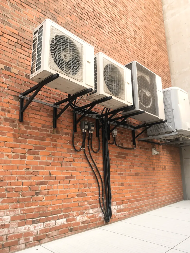 Four heat pumps on one brick wall